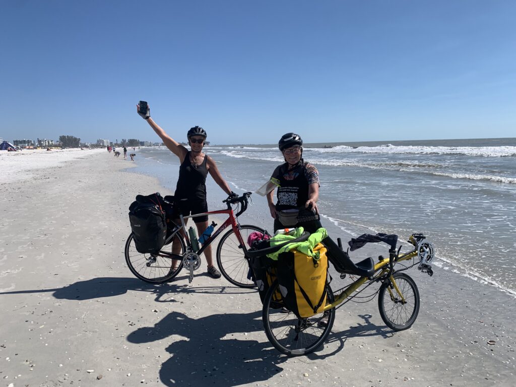 Donna and Becky with their bikes on the beach in Florida after 500 mile ride. 