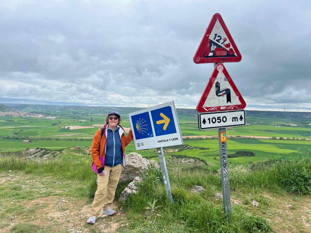 Linda Loewinger beside the sign for trail on the Camino in Spain.