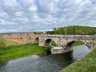 A historic bridge or old aqueduct going over a canal on the Camino in Spain.