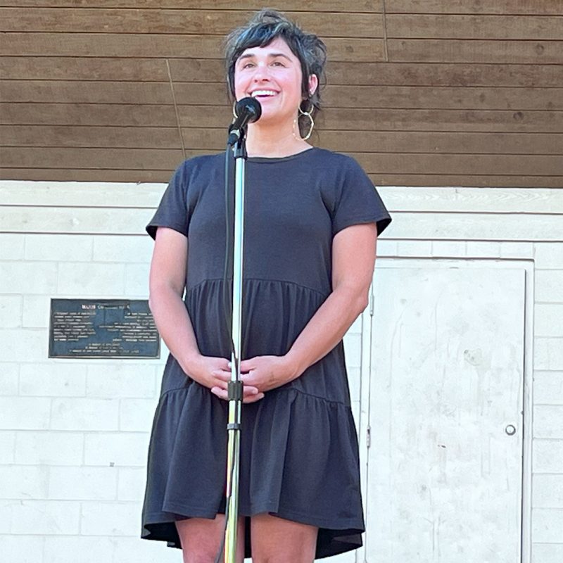 Candace Haster shares a story at a microphone